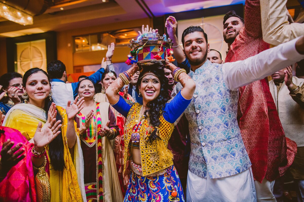 indian bride and groom dancing with the jaago on the dance floor during the sangeet event