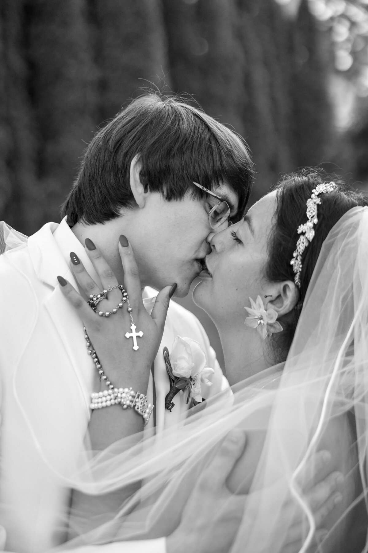 bride and groom kissing with rosary on brides wrist at the washington crossing inn wedding photography by good omen photo co