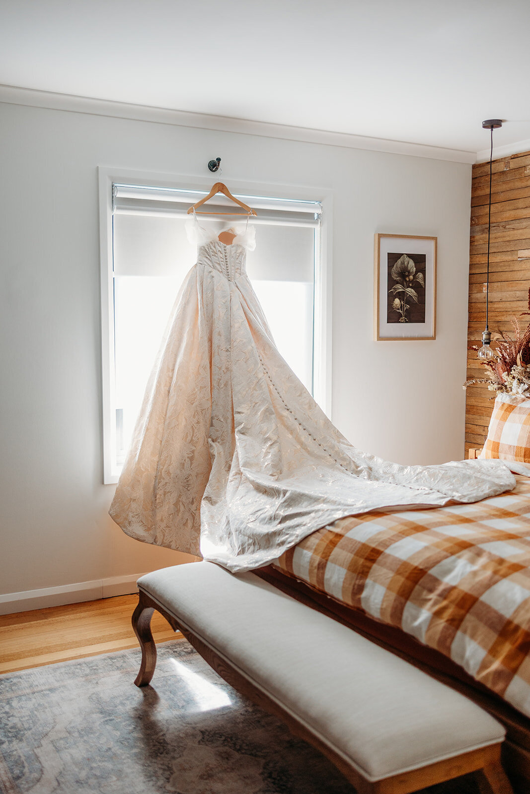 Wedding dress hanging by the window in the cottage at Petrichor Farm