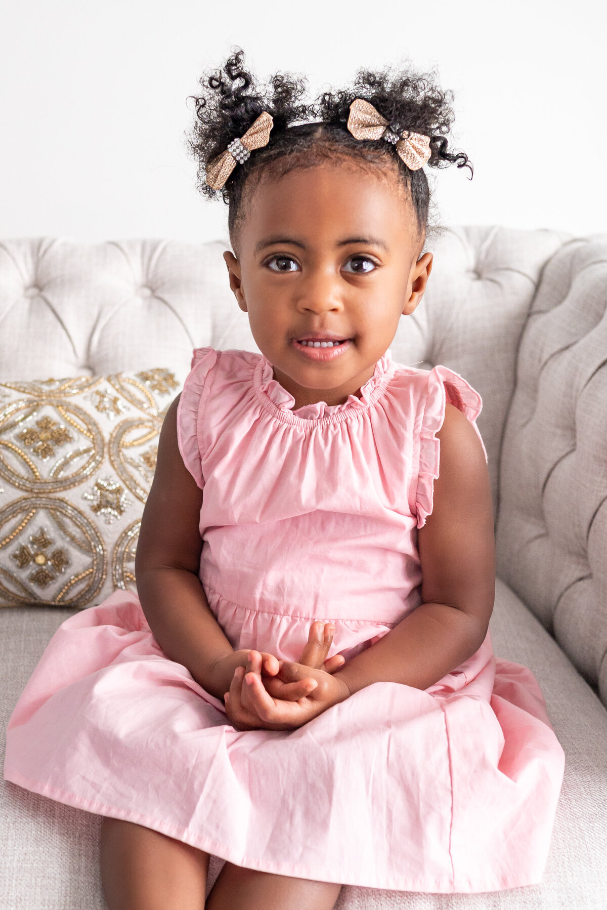 A toddler smiles for the camera in a photography studio in Huntsville Alabama