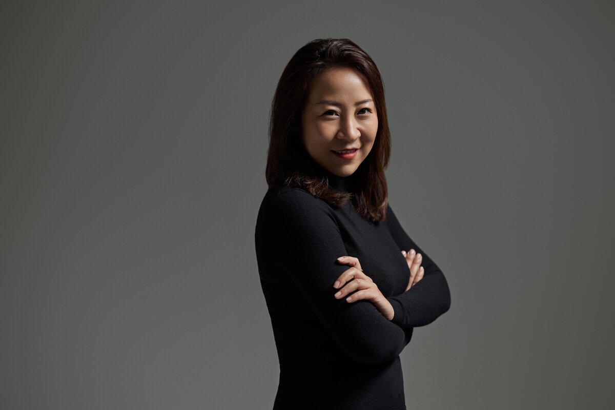 A woman with her arms crossed smiling
