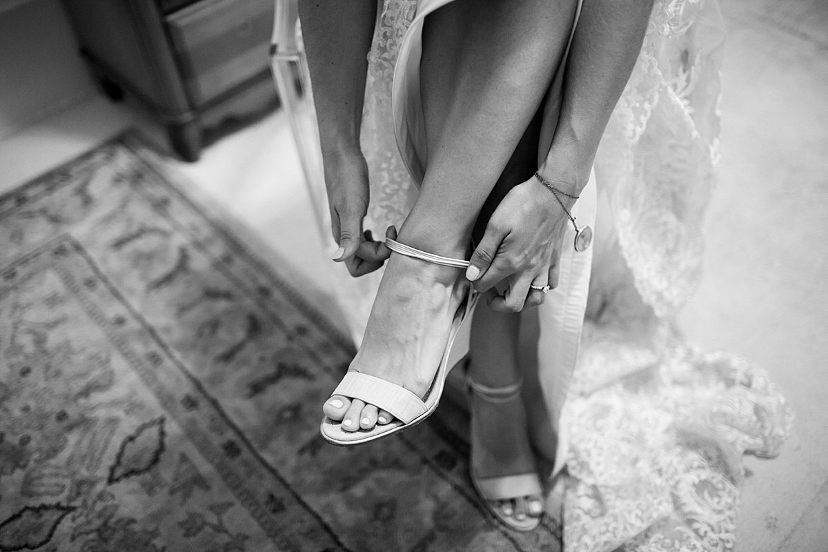 Classy bride fastening her wedding high heels