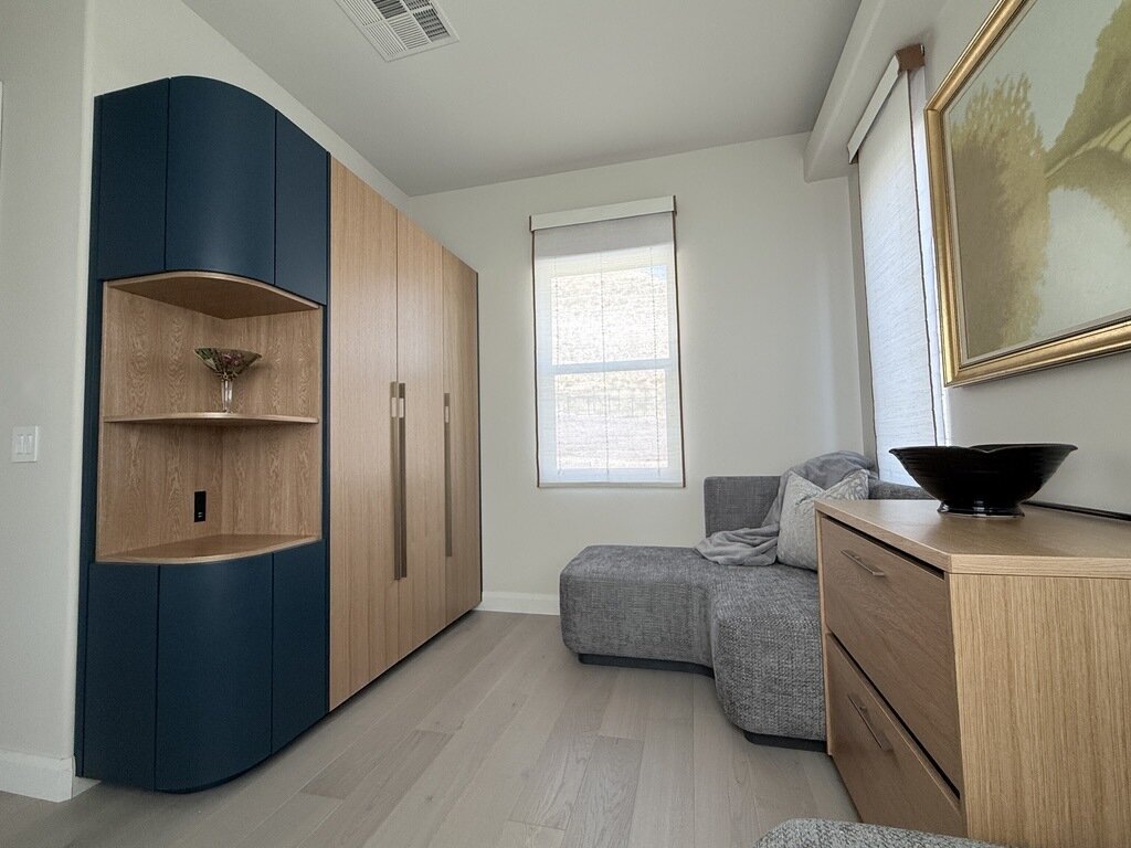 Woven wood shade on a window beside a navy built-in cabinet and a sectional sofa