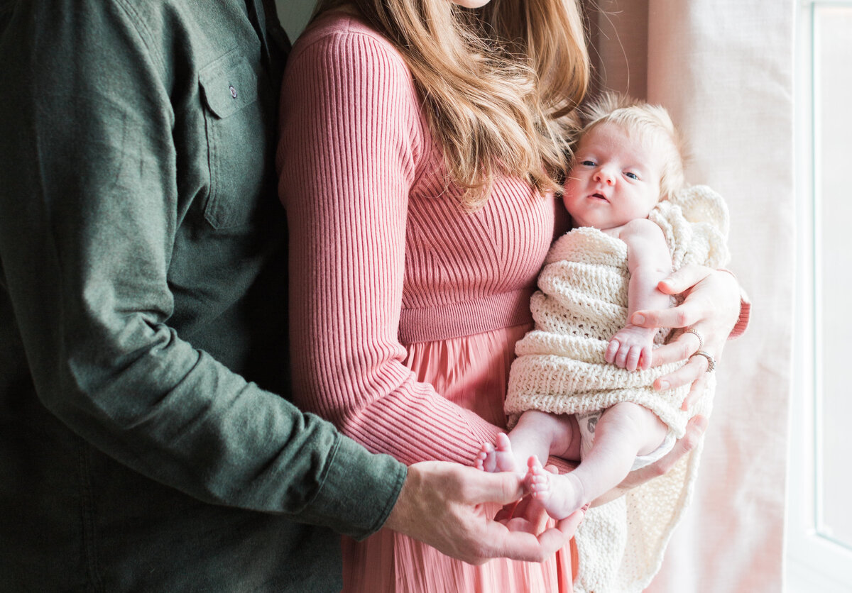 parents holding their baby during an in-home newborn session