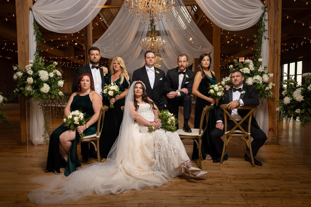 The bride and groom are posing for a picture with their wedding party