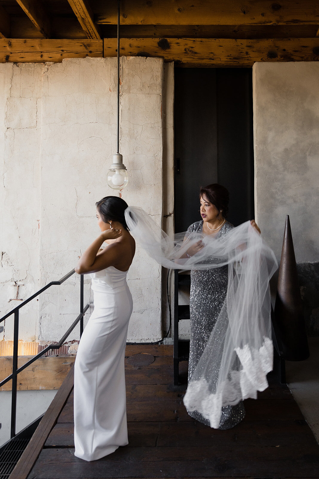 mother of bride helps to adjust brides veil