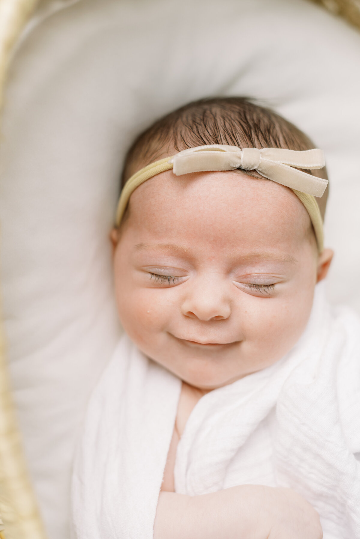 smiling newborn in bassinet