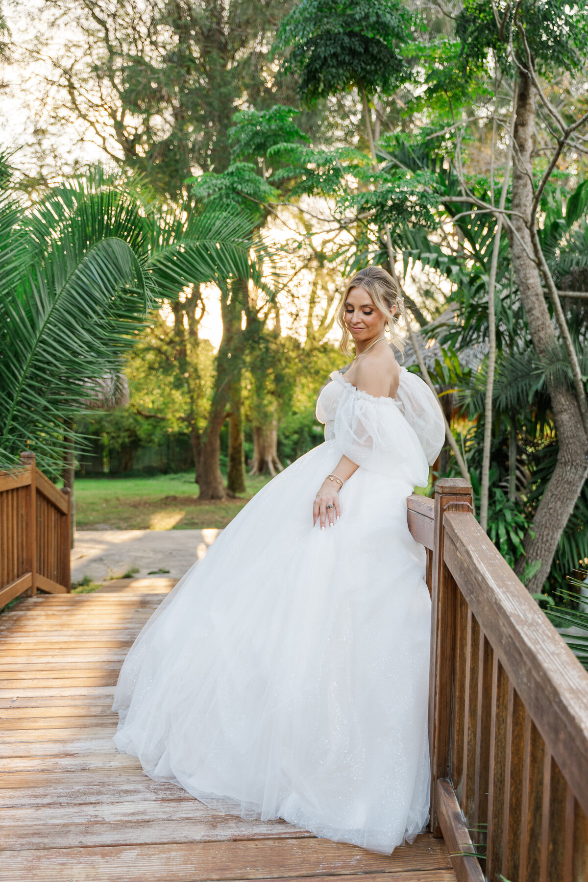a bride on her wedding dress standing on a brodge