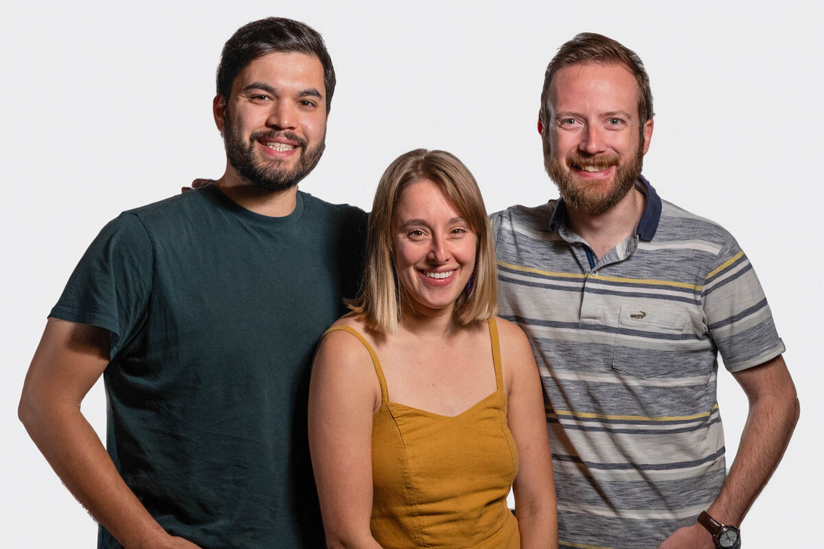 Three people standing together smiling 