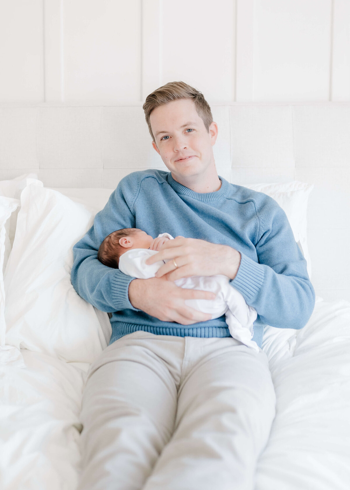 Natural light newborn portraits in Danville bedroom with soft beige tones.
