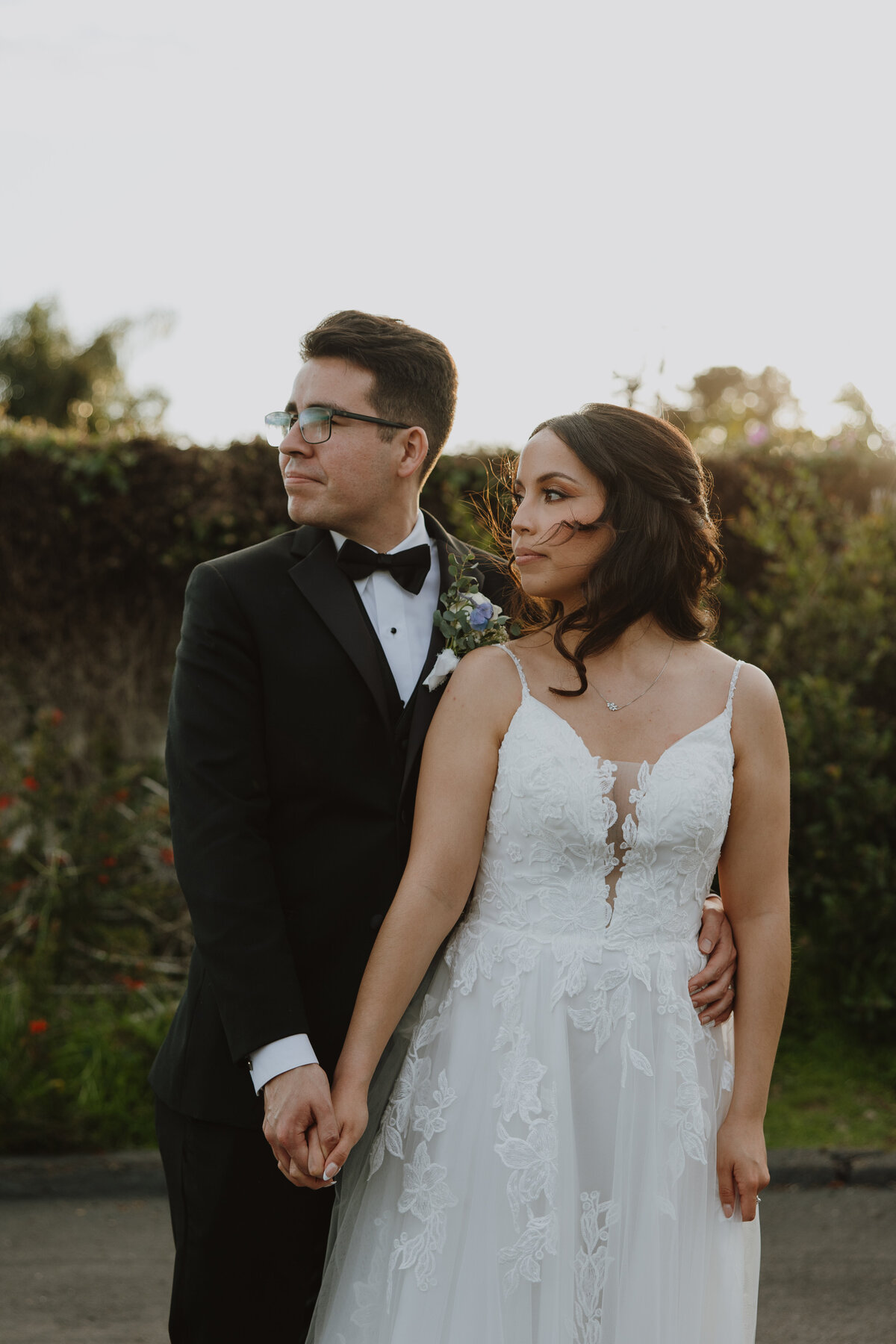 bride and groom together looking away 