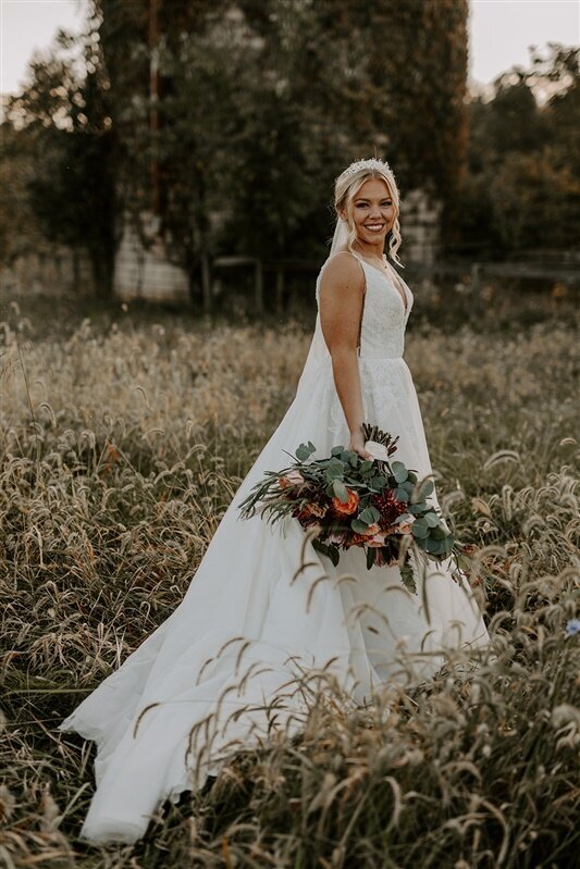 bride with her autumn bouquet in the fields