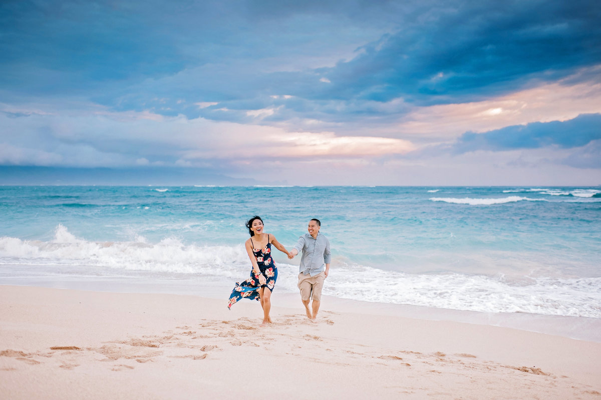 couple plays at Baldwin Beach during sunrise for their Maui honeymoon