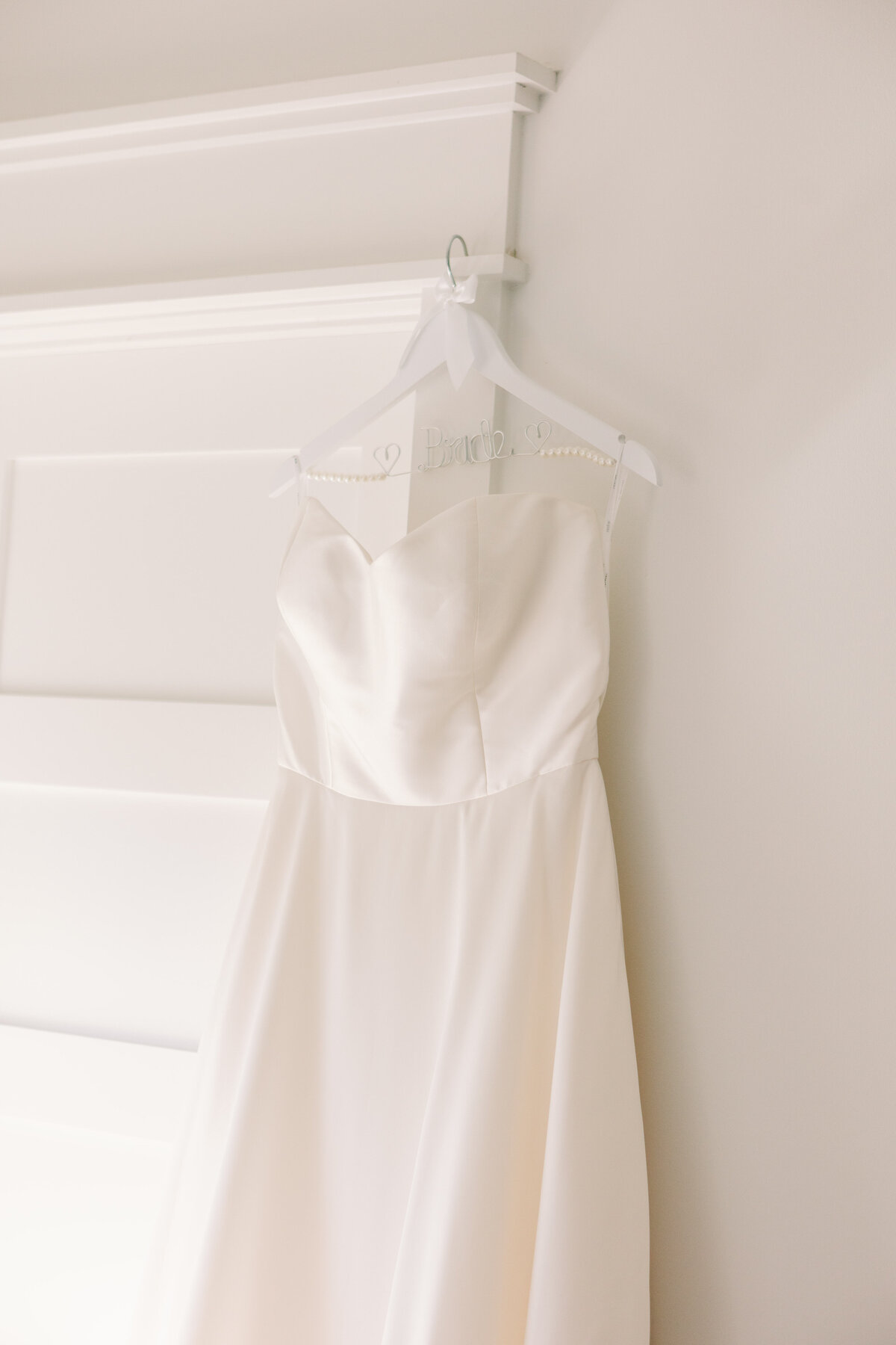 a wedding dress hanging on a door frame