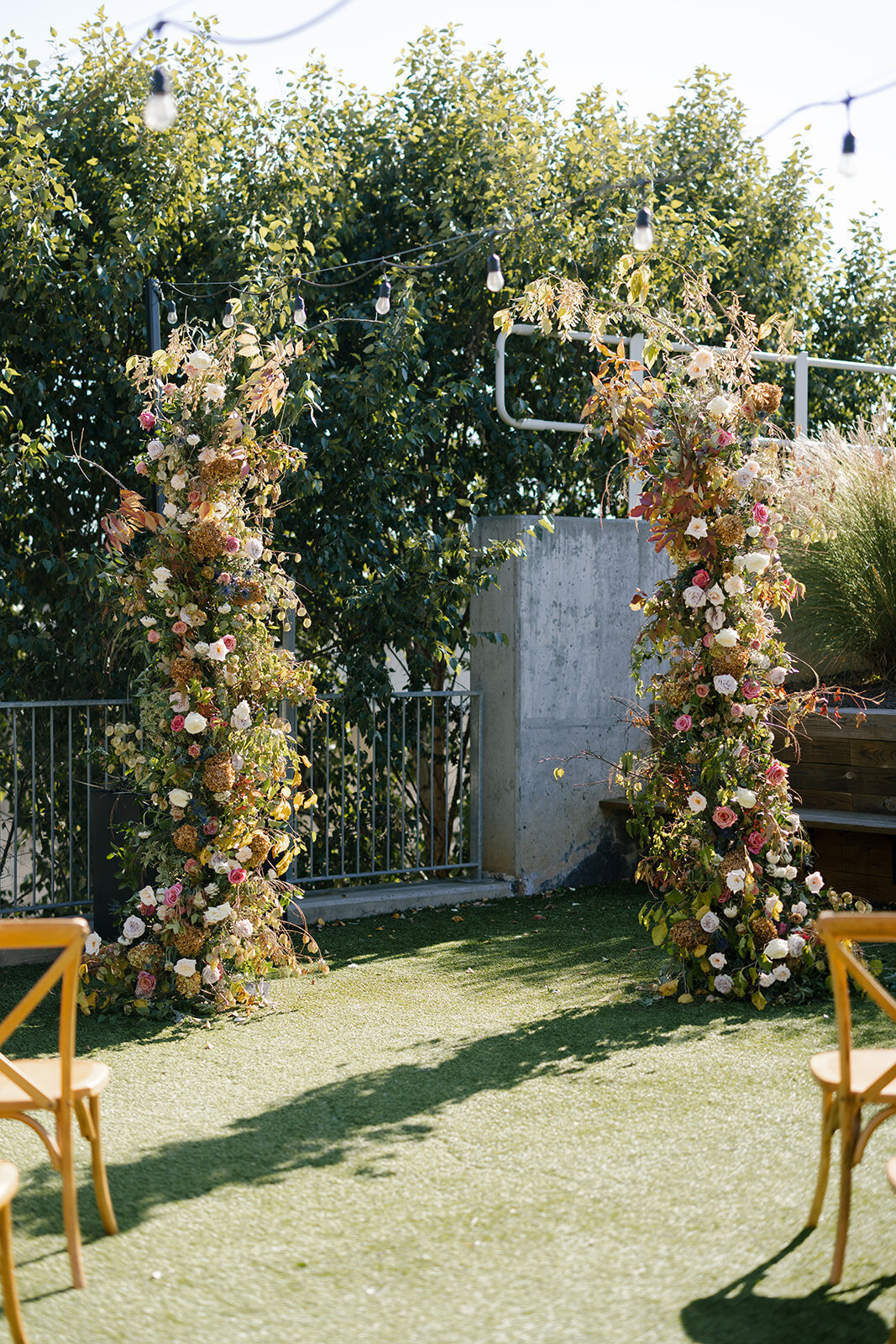 Broken Arch Ceremony Backdrop for fall Carolina’s wedding in Raleigh. Floral colors in mauve, cream, dusty pink, dusty blue, copper, and natural green. Floral accents of roses and fall color branches. Design by Rosemary and Finch Floral Design based out of Nashville, TN.