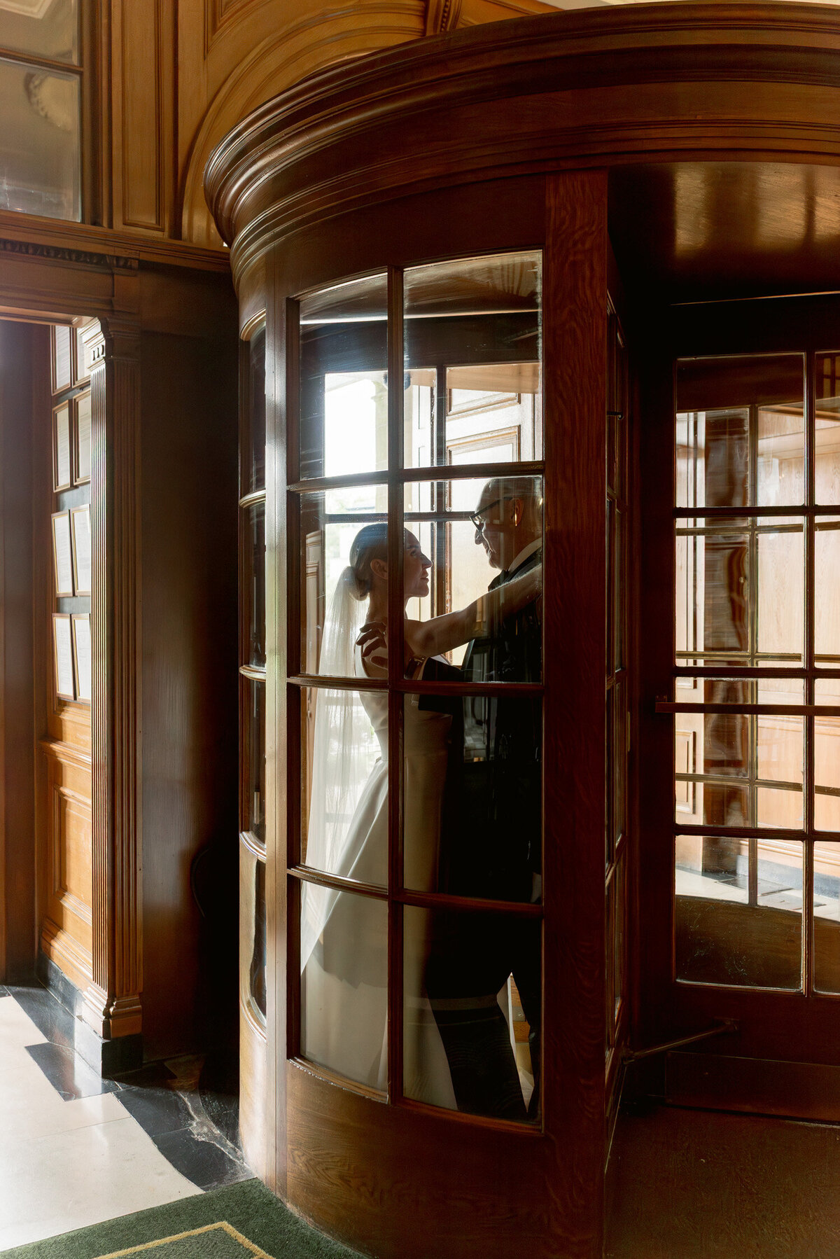 Bride and Groom in the turnstile door of Gleneagles hotel on their wedding day. Image by luxury wedding photographer Scotland, Jill Cherry Porter.