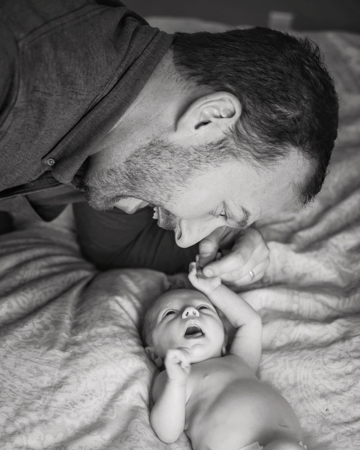 Father holds his baby's hand and sings to her