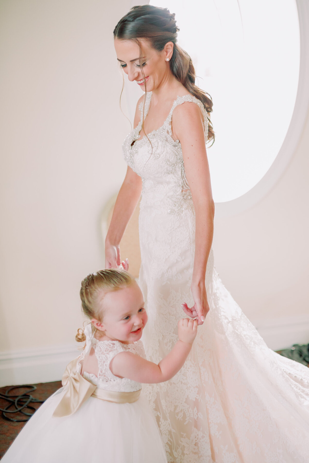  A small child dancing with a newlywed in a wedding dress 