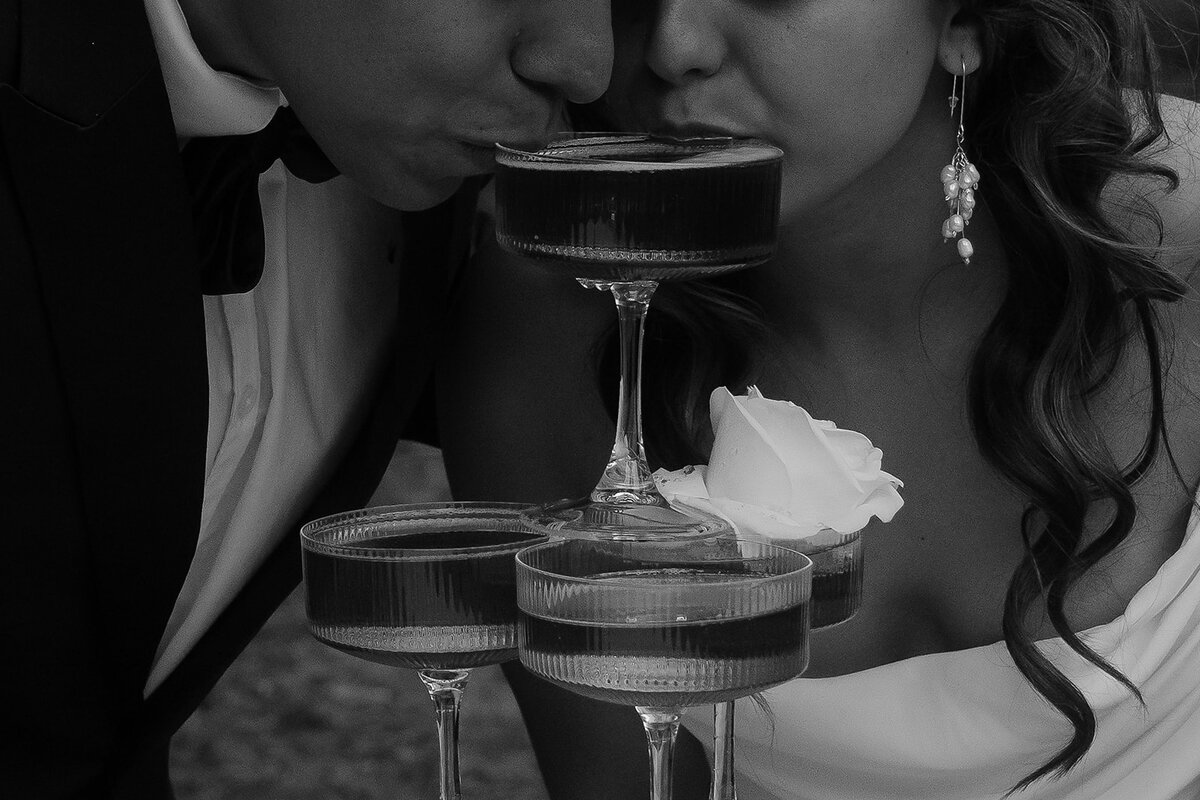 Bride and groom sipping champagne from the top of a glass tower