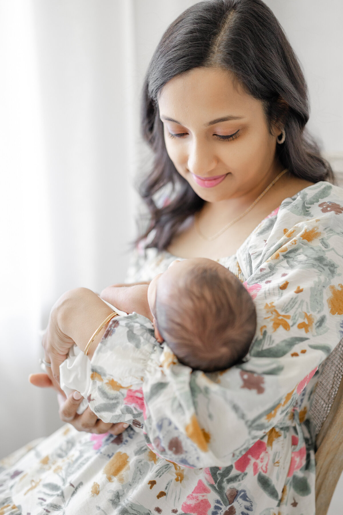 Timeless portrait of mother holding newborn baby in white wrap at South Tampa natural light studio