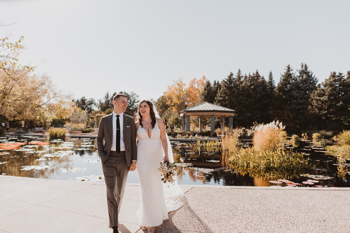 Bride and groom in front of the pond at the Denver Botanic Gardens on their wedding day.