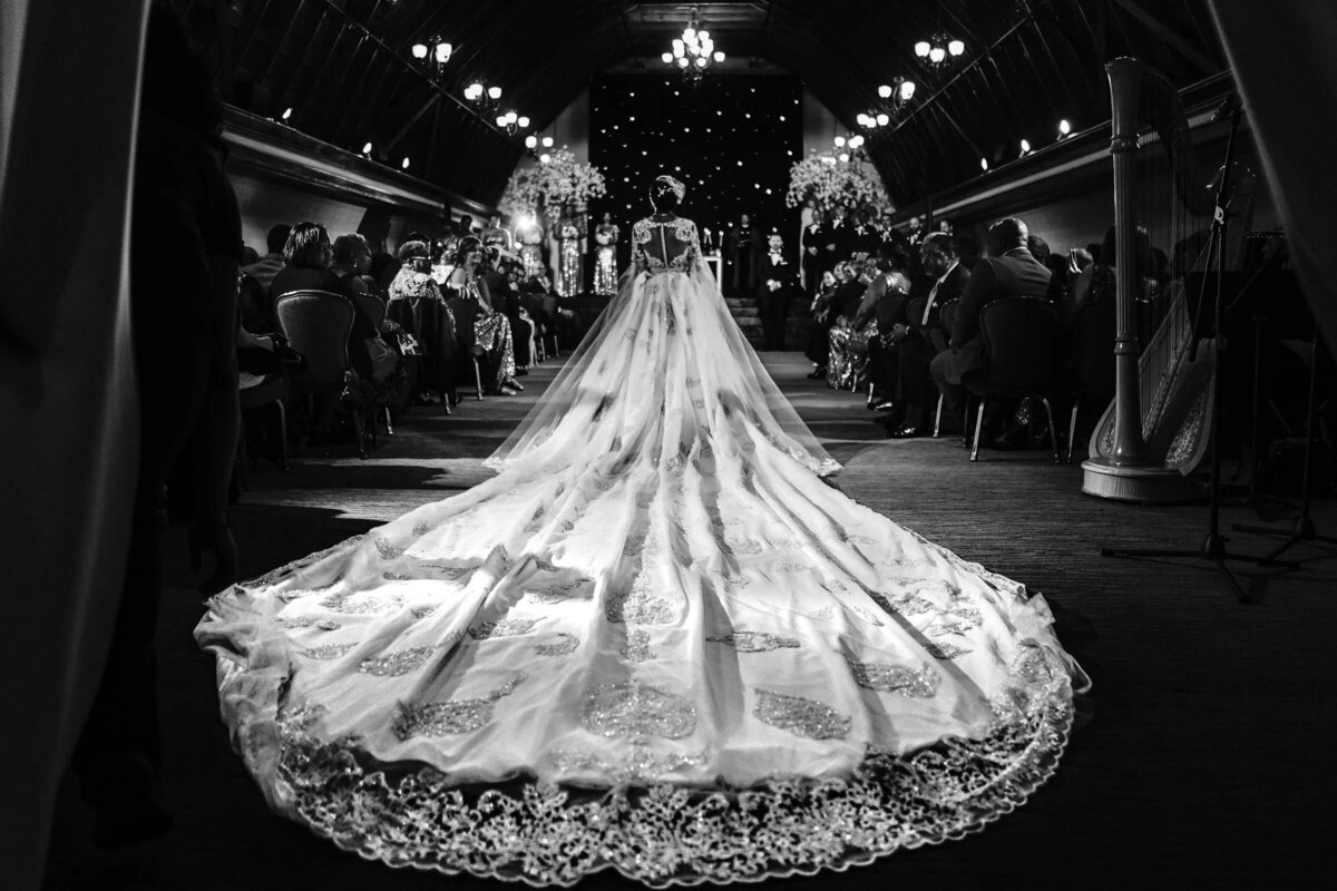 The stunning expanse of a bride's lace train spread out on the aisle of a church