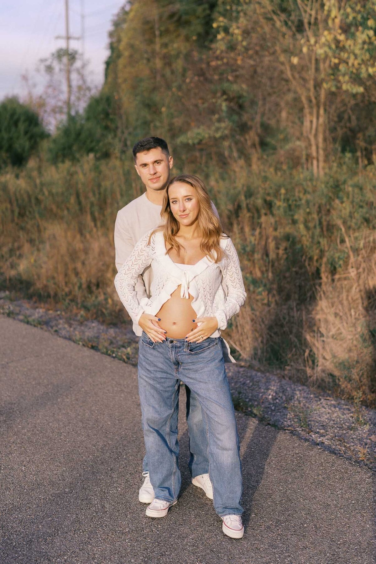 man hugs pregnant wife at sunset at seven islands park in kodak tennessee