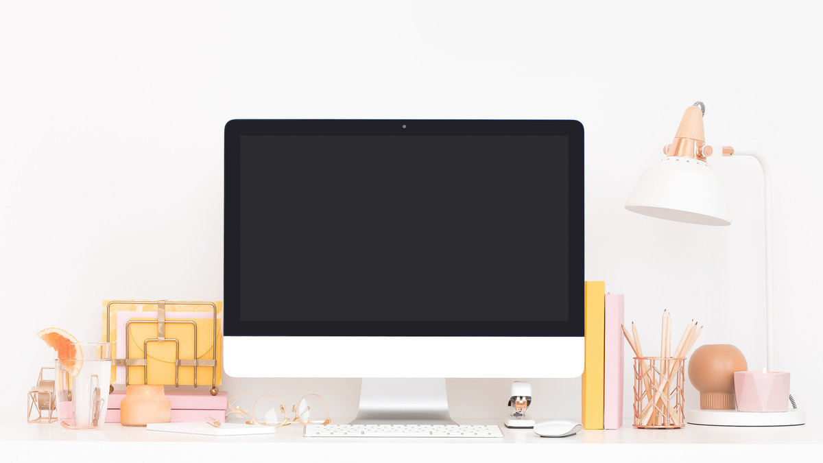 Image of iMac on computer desk with white and pink accessories