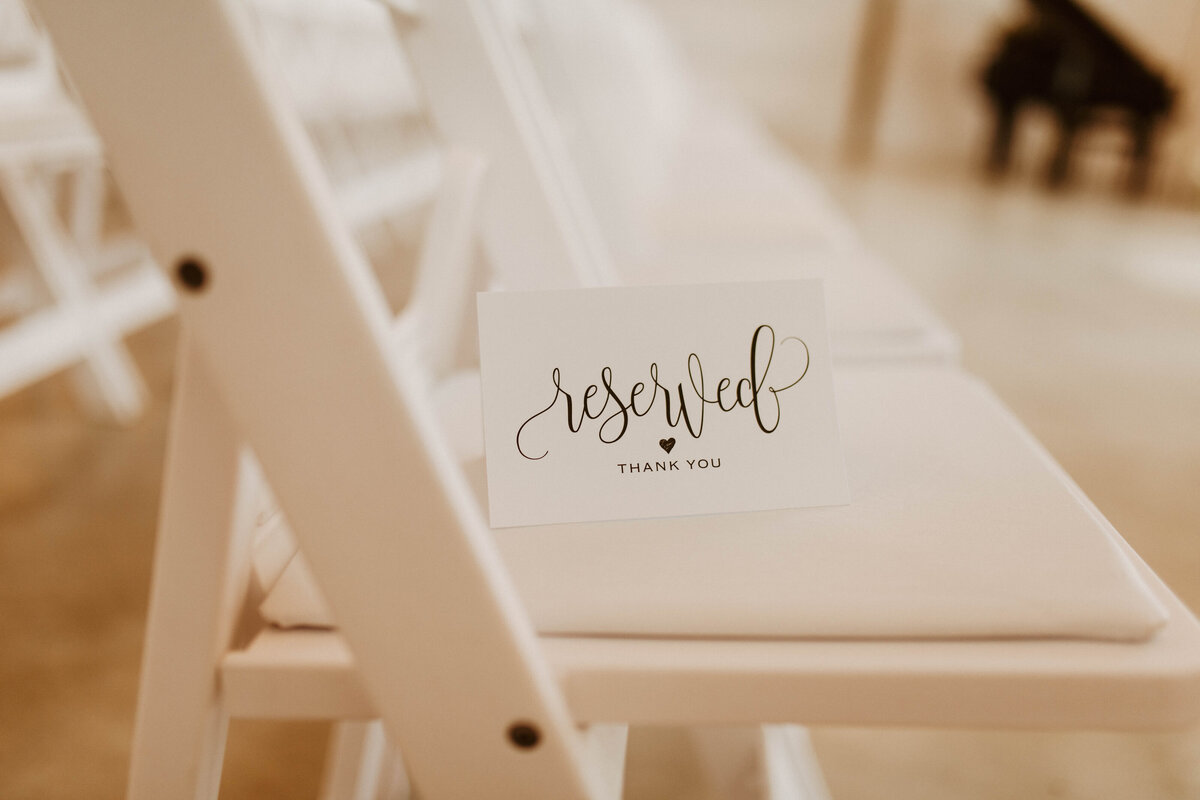 Small "reserved" note on a white chair.