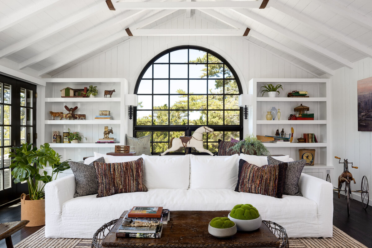 Interior design photography of a bright living room with a white sofa and arched window.