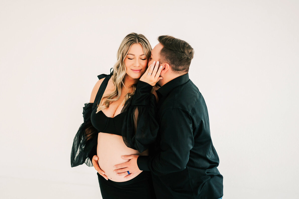 Springfield MO maternity photographer Jessica Kennedy of The XO Photography captures close up of husband kissing pregnant mom's cheek