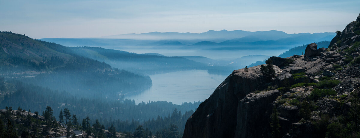 smoke is covering the mountains in the background of donner lake
