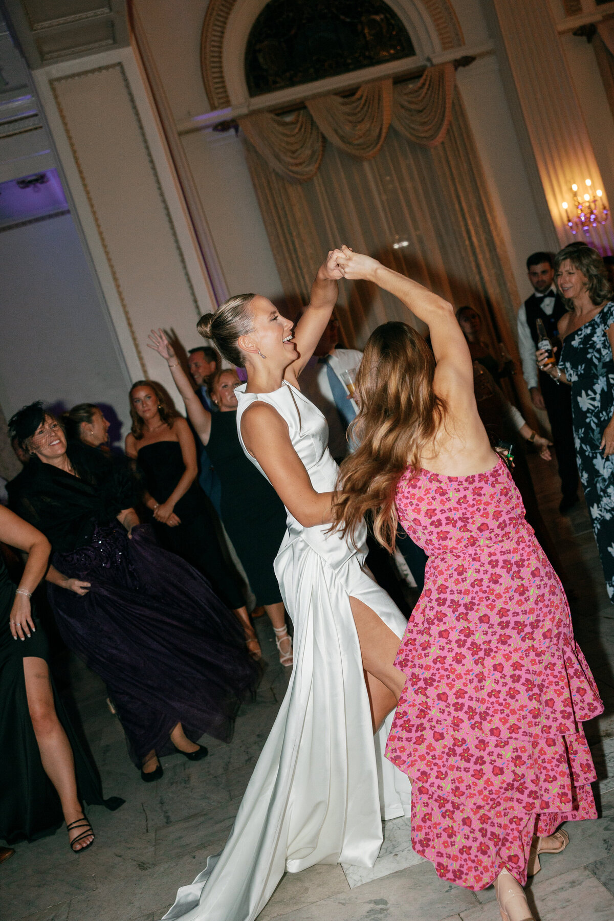 Bride dances in modern gown with guests at Philly wedding, photographed by Philadelphia wedding photographer.