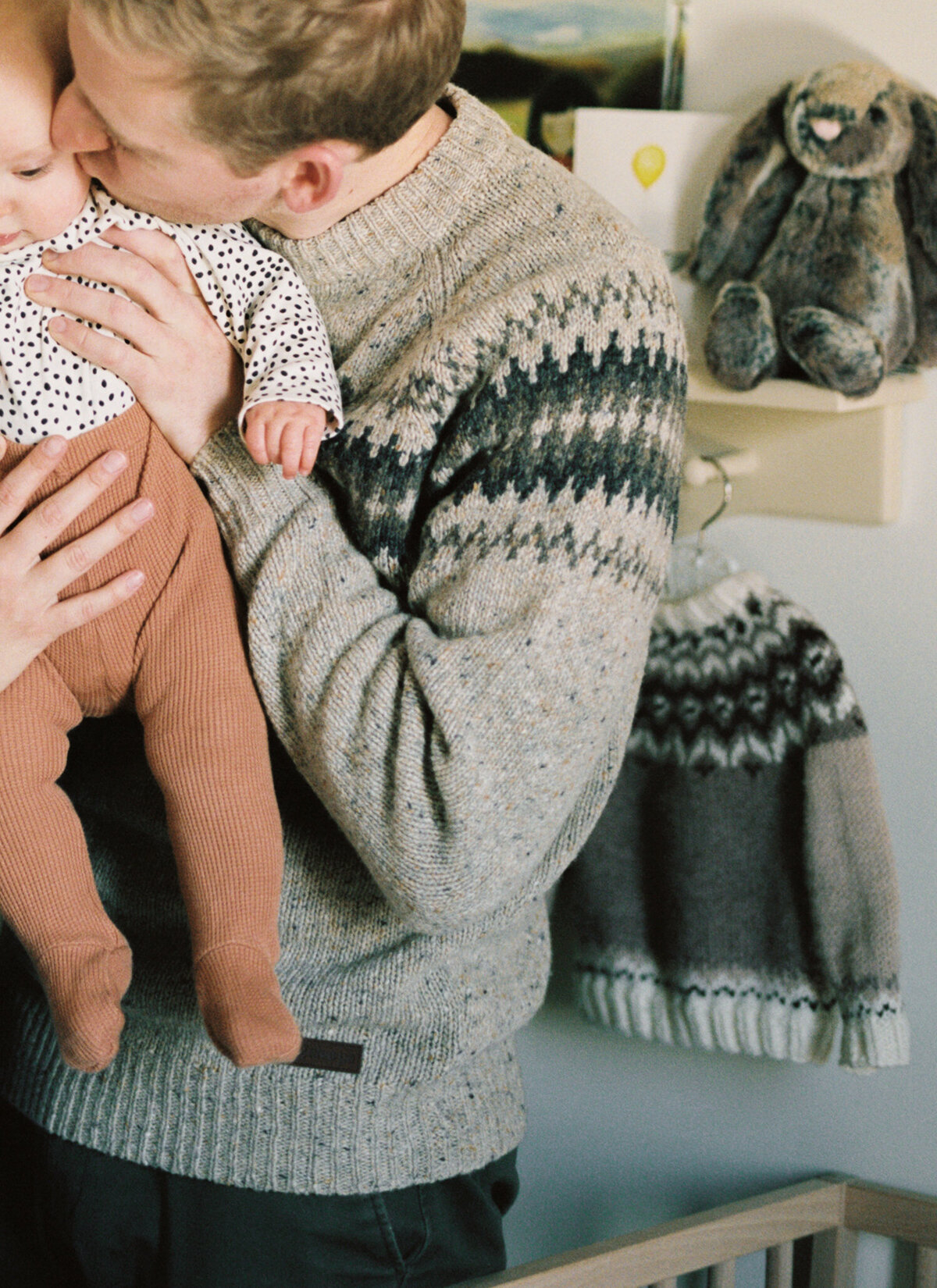 father-kissing-baby-in-nursery