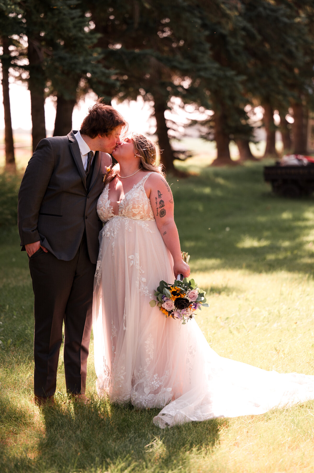 Bride and groom kissing in natural and warm wedding portrait