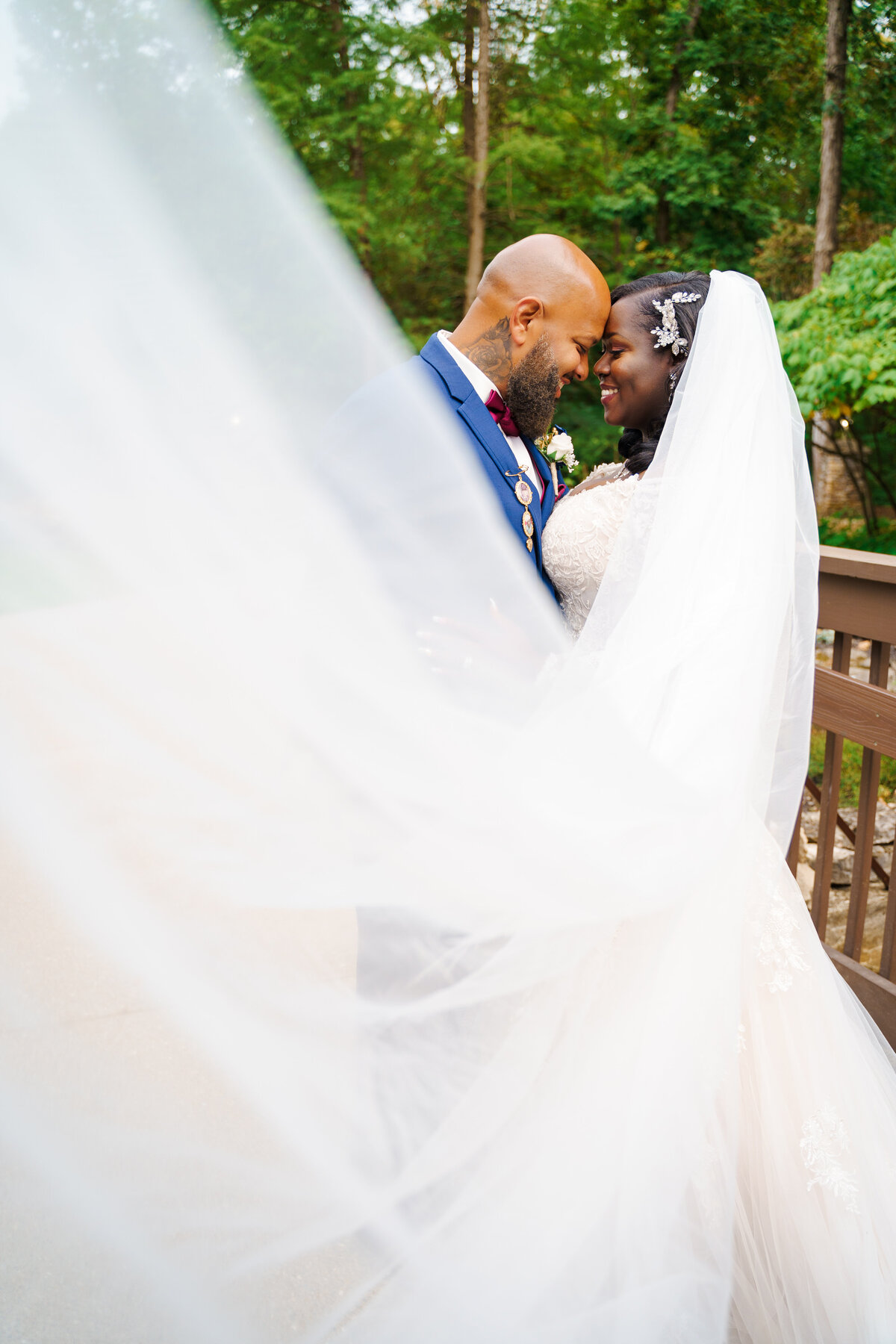 Bride and groom touch foreheads as the veil cascades into the camera at their wedding at the Wigwam Event Center in Pickerington, Ohio.