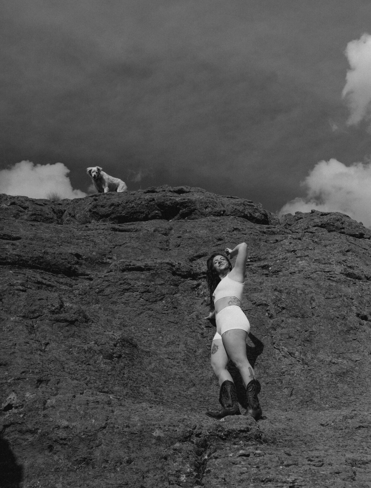 woman stands among the Moab, Utah scenery with her dog on a beautiful, warm and sunny day