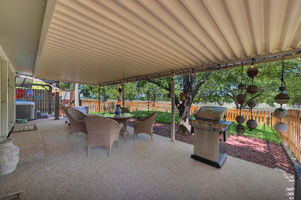 Spacious covered patio with gas grill and hot tub at this three-bedroom, two-bathroom vacation rental home with hot tub, firepit, and free WiFi just minutes from Lake Waco.