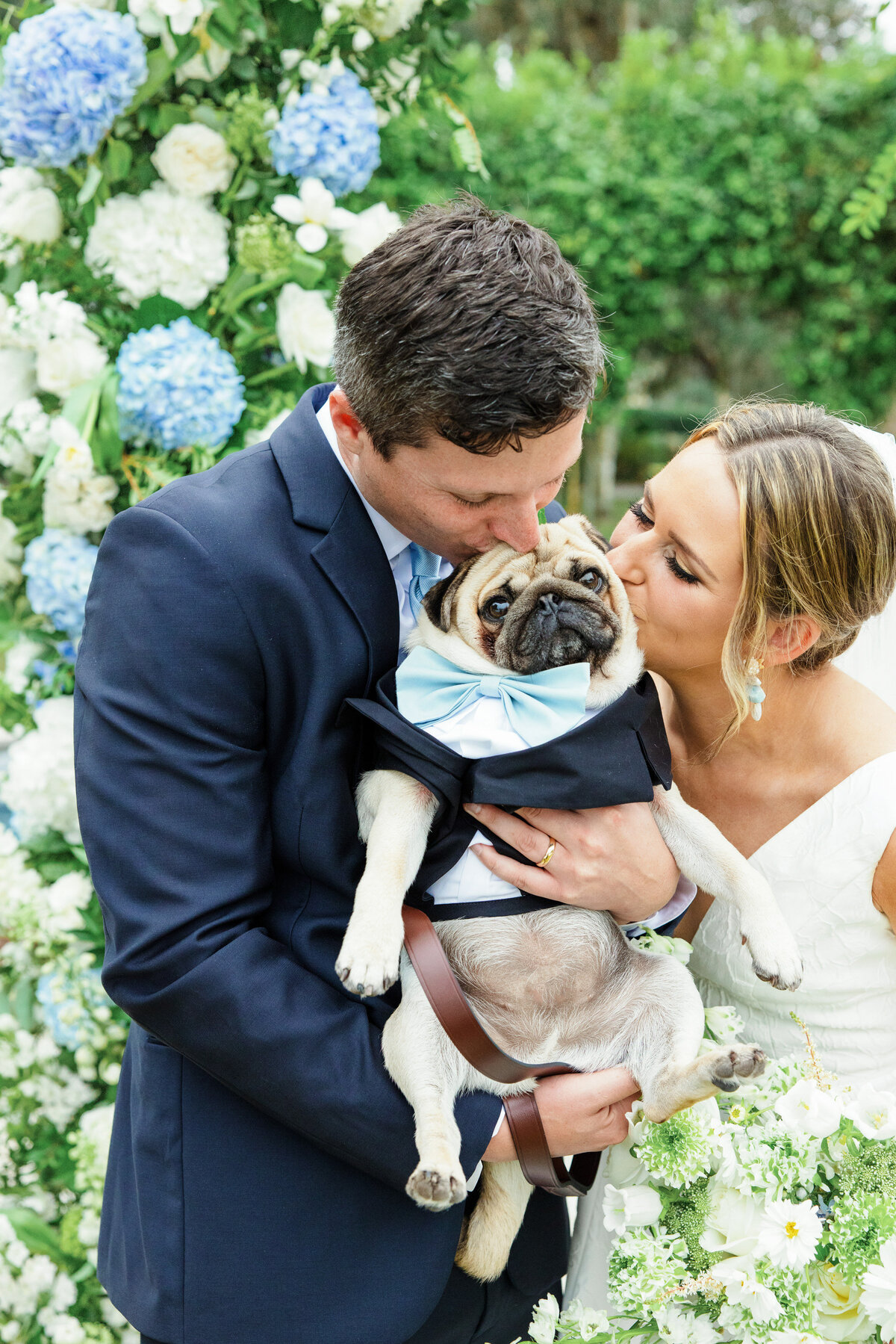 bride and groom kiss their dog after the ceremony