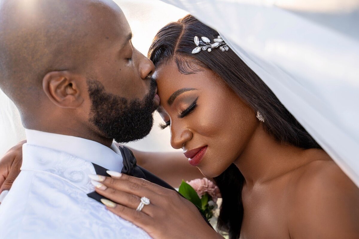 groom-kisses-bride-forehead-tender-moment