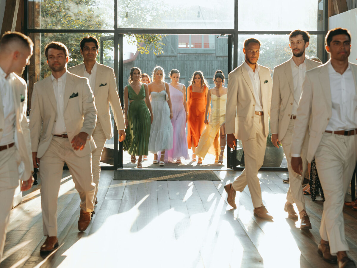 groomsmens in tan suits and bridesmaids in a rainbow of colors are announced at a reception at Willowbrook wedding venue