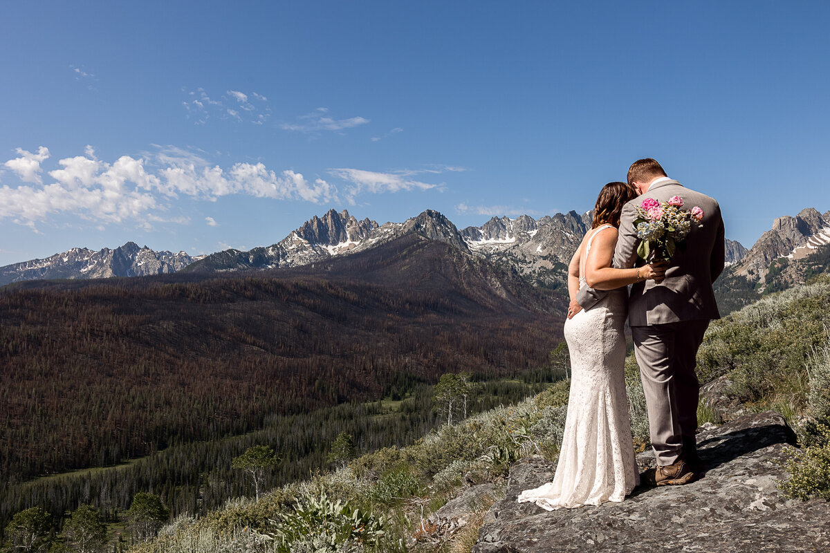 Bride and Groom sharing a moment after sharing vows facing away towards Sawtooth Mountains