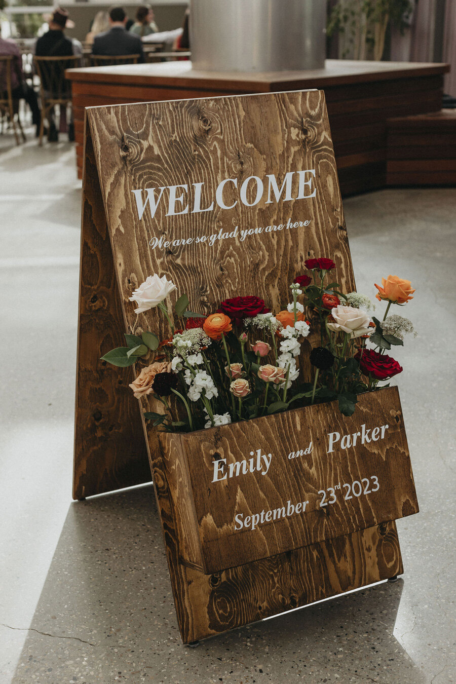Wood welcome sign at wedding ceremony.
