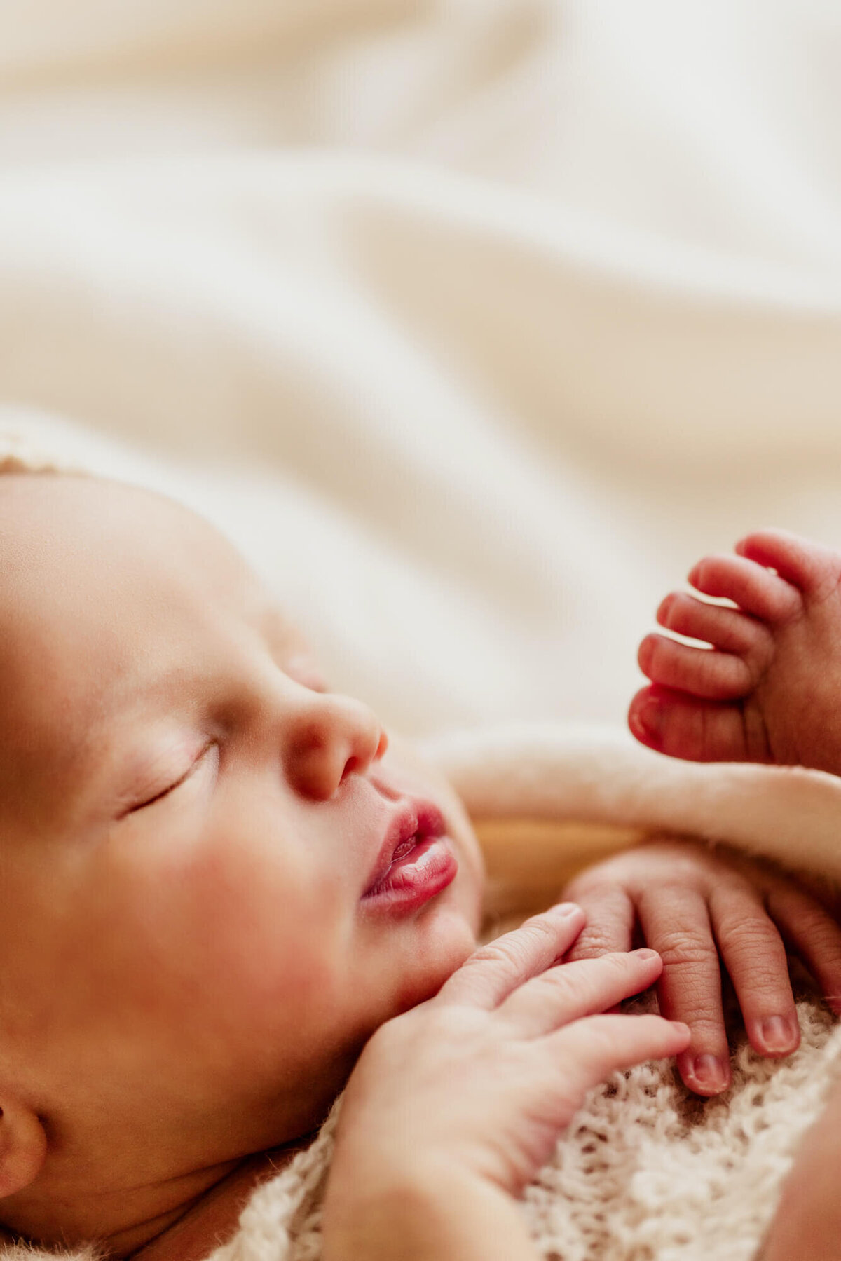Baby girl with her hands near her chest under her chin.