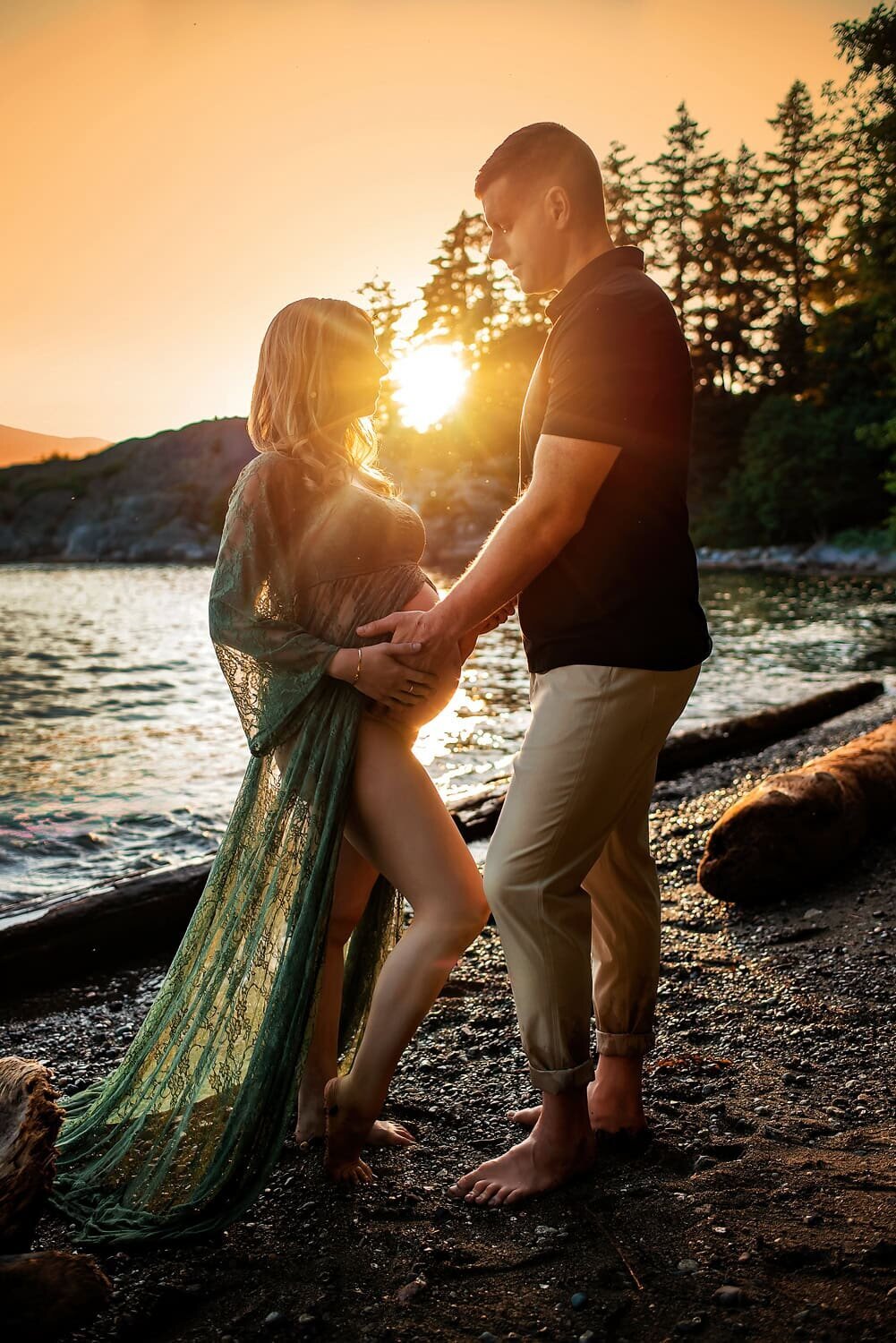 Expecting couple standing by the water during golden hour at Whytecliff Park in West Vancouver.