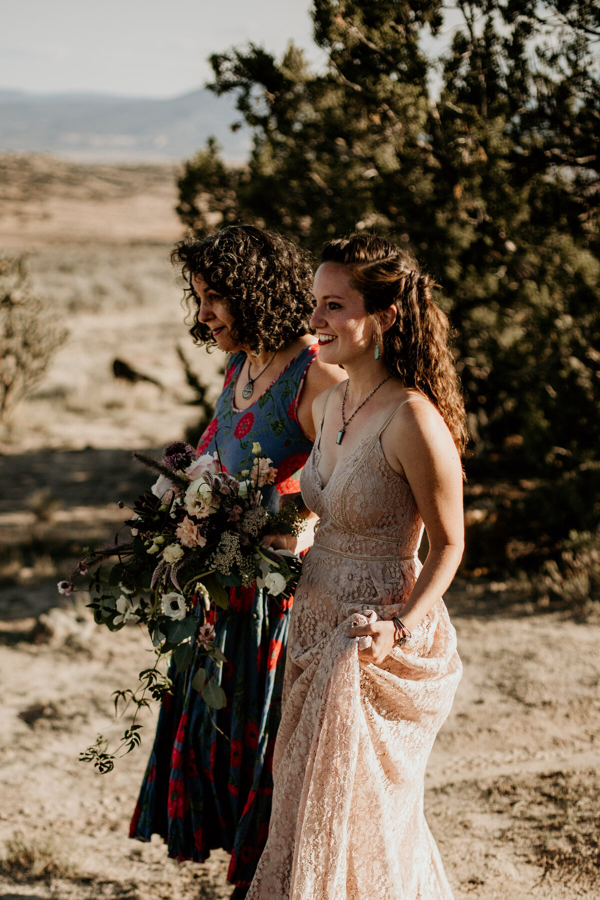 bride walking down aisle with mom in the desert