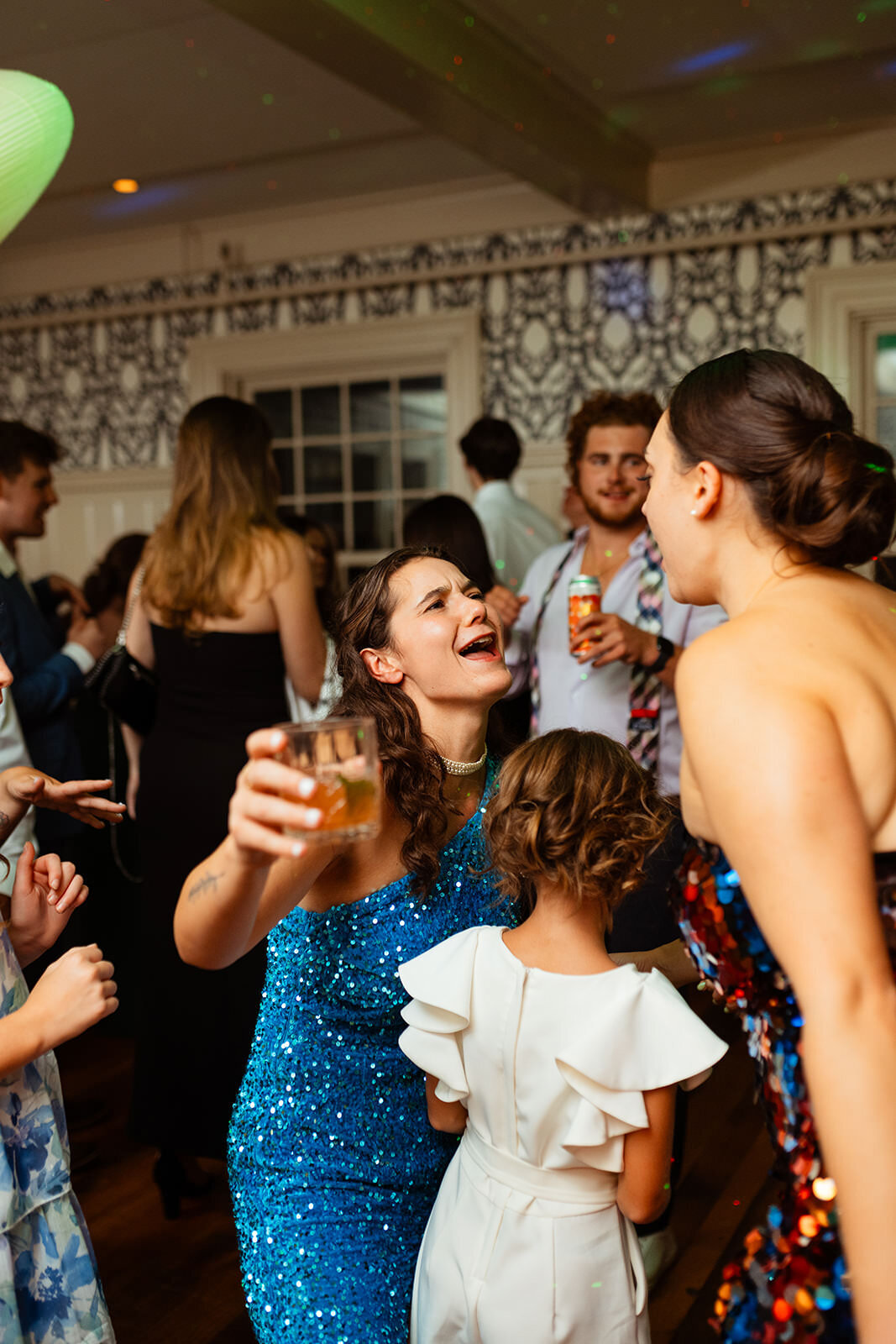 Brides in sparkly dresses with drinks in hand