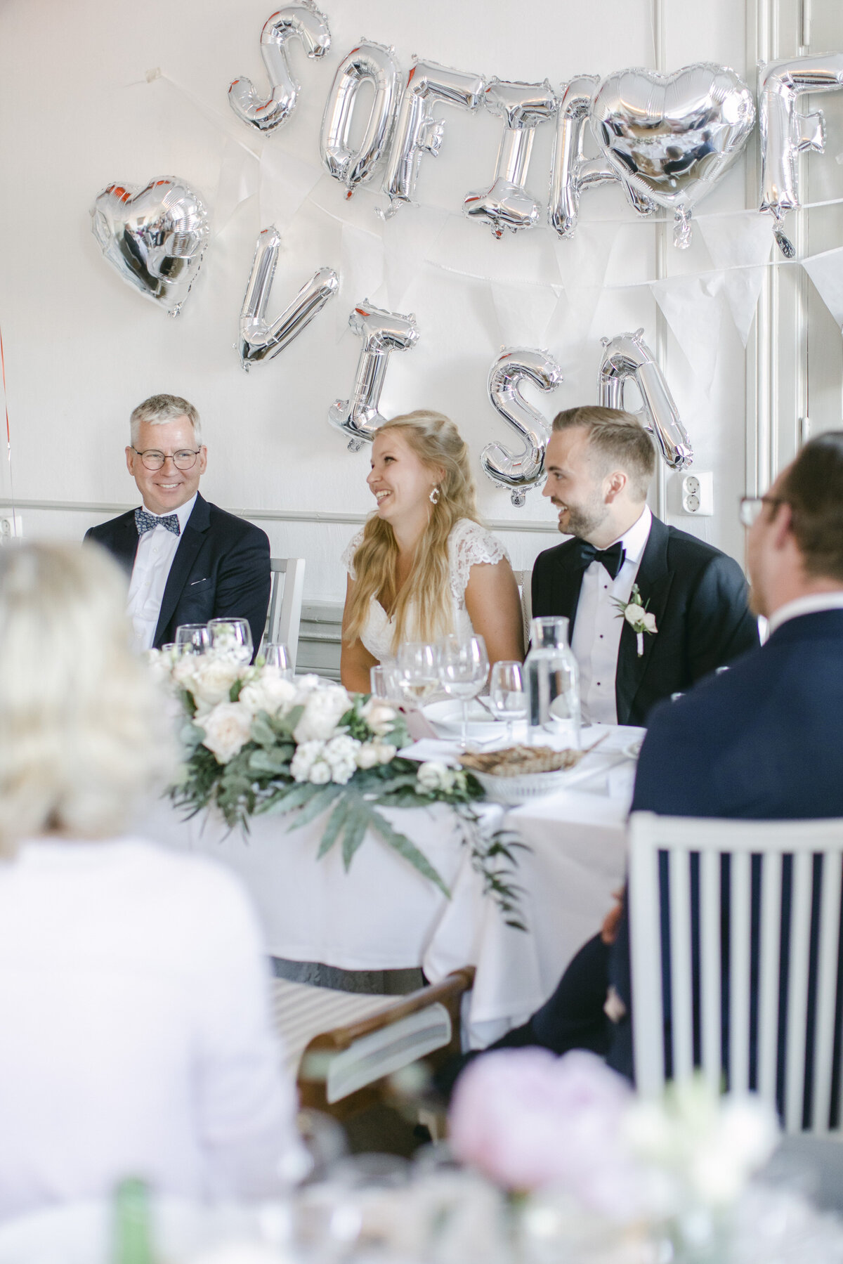Bröllopspar skrattar under talen på bröllopsmiddagen på Schenströmska