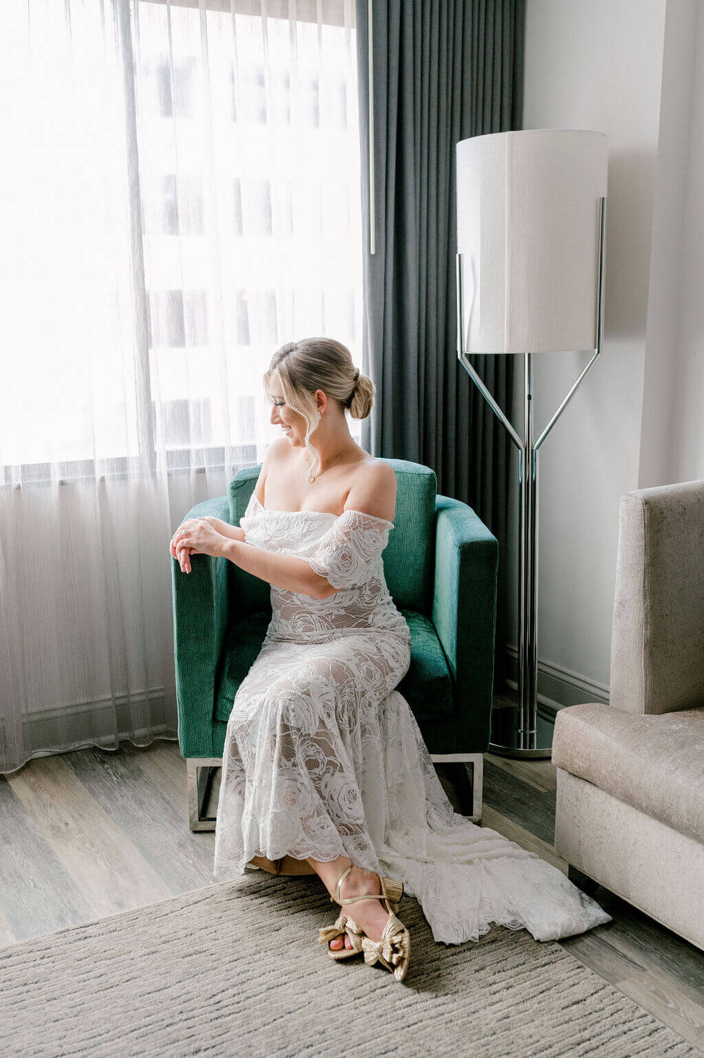 A simple bridal portrait of a bride sitting in a green chair.
