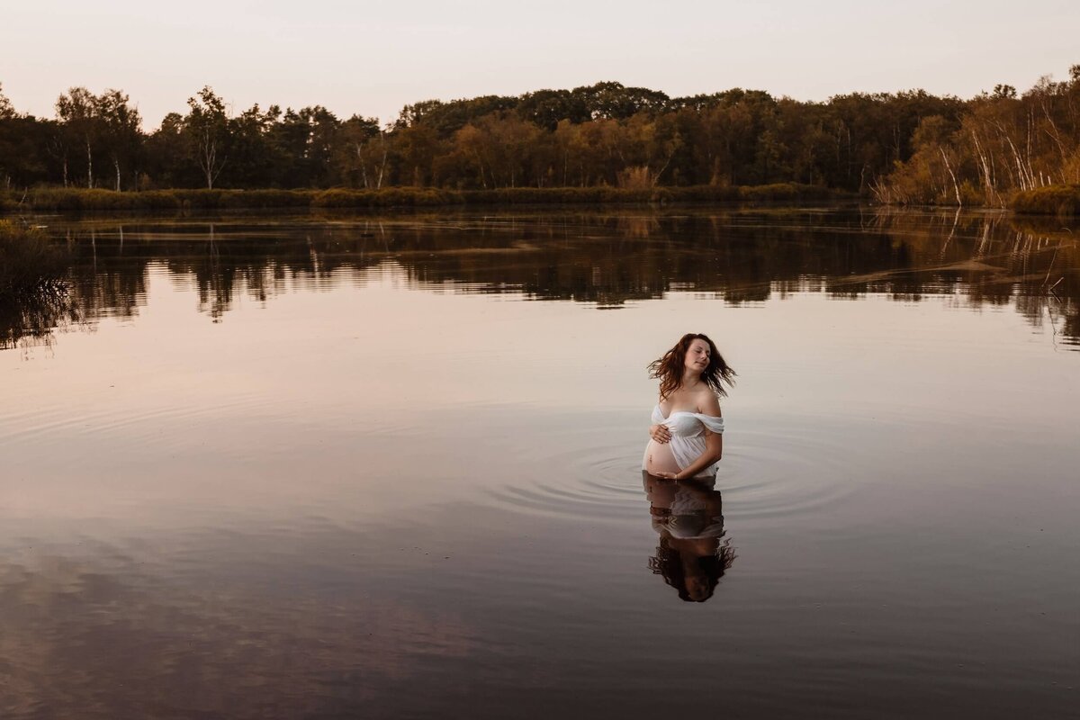 zwangere vrouw in water tijdens zonsondergang door fotograaf Eline Hemelt
